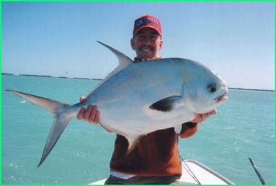 charter guest holding a big permit fish